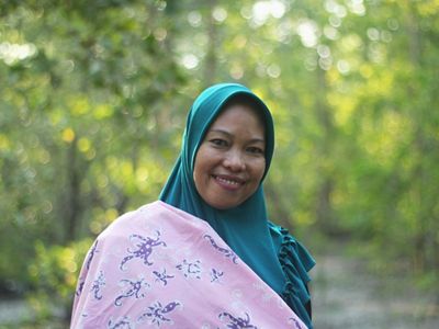 Salah seorang anggota kelompok perempuan Kampung Teluk Semanting membawa produk batik hasil karya mereka.