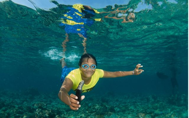 A woman holding a sea cucumber.