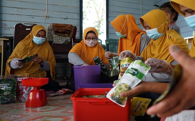 Ibu-ibu Kelompok Kurindam Sanggam Merancang Ulu sedang mengemasi produk unggulan.