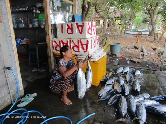 Ibu sedang menjual hasil tangkapan nelayan