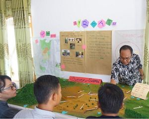 Sekretaris Desa Gunung Sari (Bpk Darwis) menjelaskan Peta 3D kepada warga yang mengikuti pelatihan di Kecamatan Segah (Maret 2018).