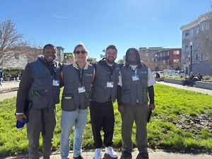 Four F2F canvassers pose while smiling on a sunny day. 