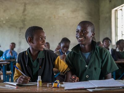 Two boys at a desk in their classroom.