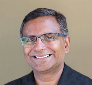 Headshot of smiling man with glasses.