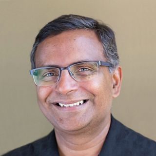 Headshot of smiling man with glasses.