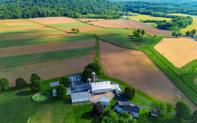 A drone photo looking down on to a farm house surrounded by farm fields.