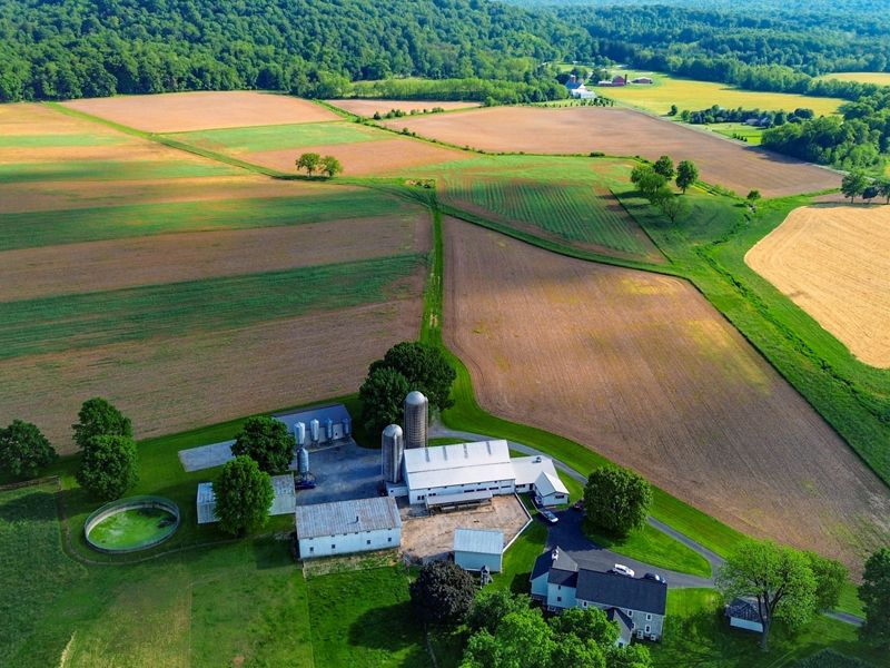 A drone photo looking down on to a farm house surrounded by farm fields.