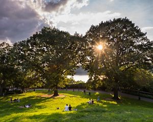 People enjoy the afternoon on the Billings Lawn of Fort Tryon Park along the Hudson River in Upper Manhattan, New York.